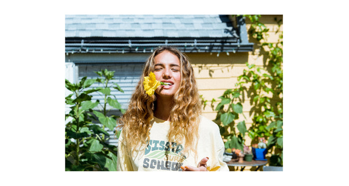 Sisstrevolution and Rose Machado: Vibrant outdoor portrait with a sunflower.