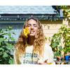 Sisstrevolution and Rose Machado: Vibrant outdoor portrait with a sunflower.