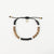 Sulawesi Sands bracelet with black, white, and brown beads and charm.