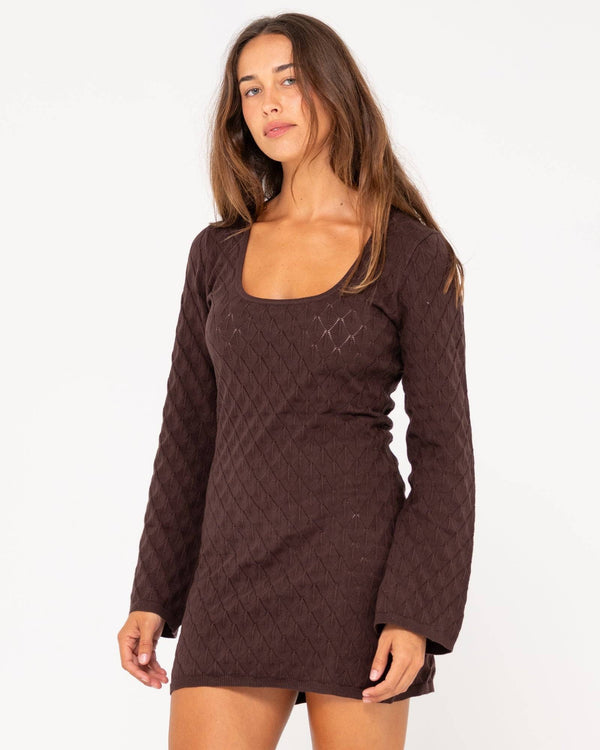 Side angle of Rusty Leo long sleeve knit mini dress in brown with a fitted silhouette.