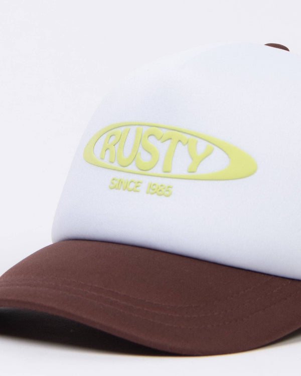 Close-up of Rusty Bless You Trucker Cap logo in yellow text.