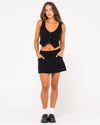 Model wearing Rusty Sicily Mid Rise Mini Skirt with matching black top.