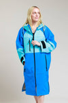 Woman modeling the White Water cobalt blue soft shell robe, emphasizing its relaxed fit and hood.