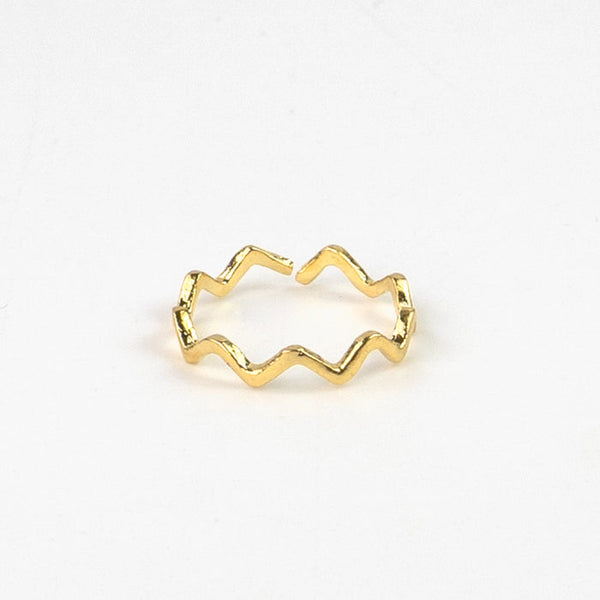 Close-up of gold ripple wave ring on white background.