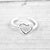 Silver hollow heart ring by Pineapple Island on a wooden background.