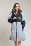 White Water Adult Hard Shell Robe in grey, zipped up, modeled by a smiling woman.