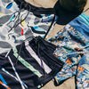 Upcycled coconut boardshorts by Vissla displayed on sandy beach with coconuts.