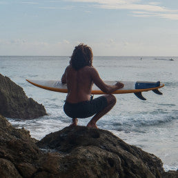 man at the besch with a surfboard