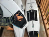 Surfboards with traction pads and surf hardware on a tiled balcony.