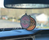 Mr. Zog's Sex Wax air freshener hanging from a car's rearview mirror.