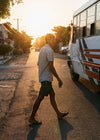 Man wearing Vissla No See Ums Eco walkshort in moss, walking at sunset.