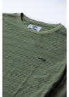 Close-up of Vissla Creek Ss Tee, fatigue green, with logo detail and stripe pattern.