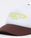 Close-up of Rusty Bless You Trucker Cap logo in yellow text.