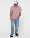 Man styling Rusty Bless You Trucker Cap with pink shirt and jeans.