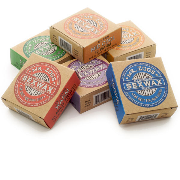 Assorted boxes of Mr. Zog's SexWax Quickhumps surfboard wax in various colors.