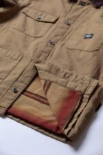 Interior view of Vissla Peterson Jacket showing striped lining in warm tones.