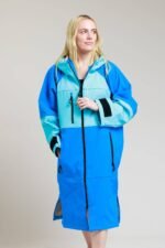 Woman modeling the White Water cobalt blue soft shell robe, emphasizing its relaxed fit and hood.