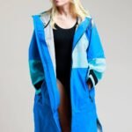 White Water Adult Soft Shell Robe in cobalt blue worn by a woman, showcasing its hood and long design.