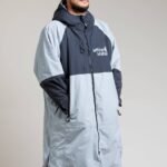 White Water Adult Hard Shell Robe in grey with hood, modeled by a man.