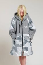 Child wearing White Water Kids Hard Shell Robe in Arctic Camo/Grey with hands in pockets.