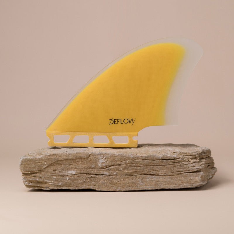 palm-mustard_bf33bc17-f1b4-4126-9bde-085e5d32a1fb Deflow Palm twin fin in mustard color displayed on a stone base.